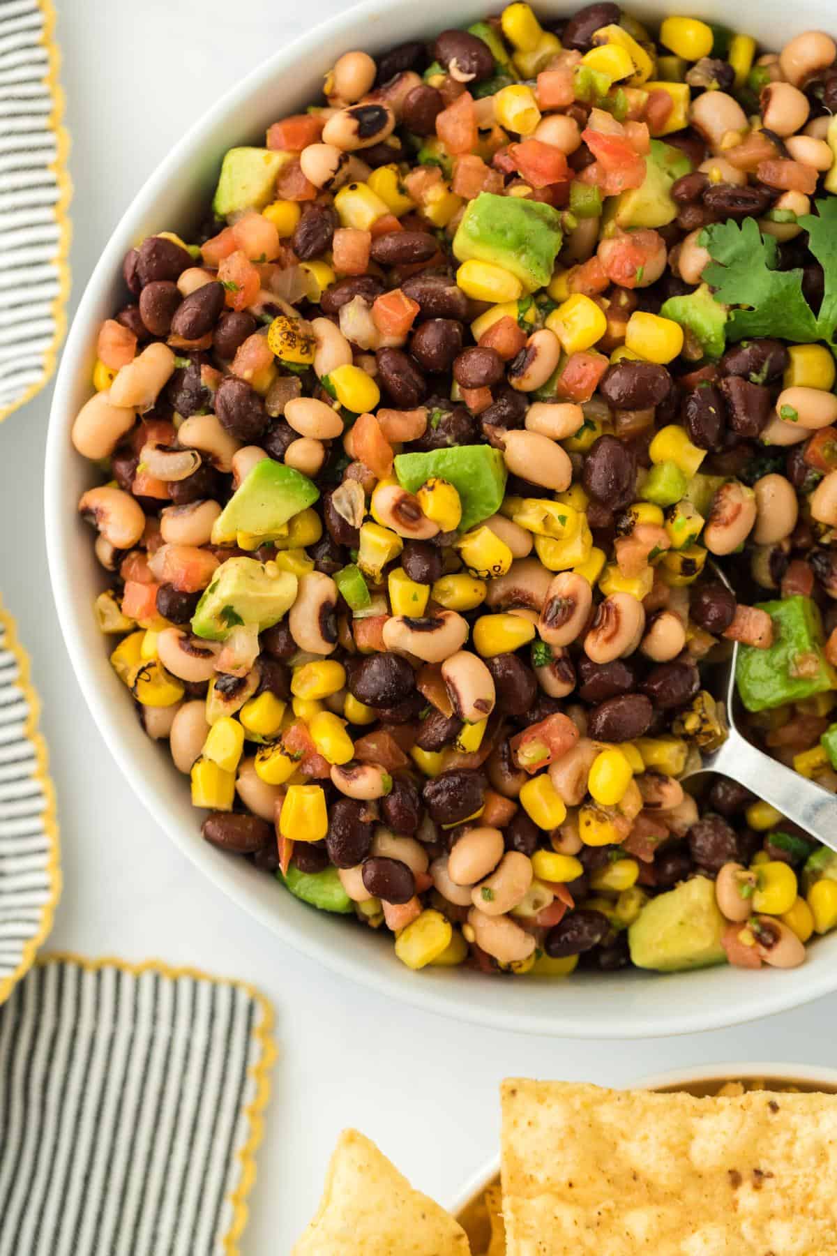 A closeup of cowboy caviar in a bowl with a spoon in it