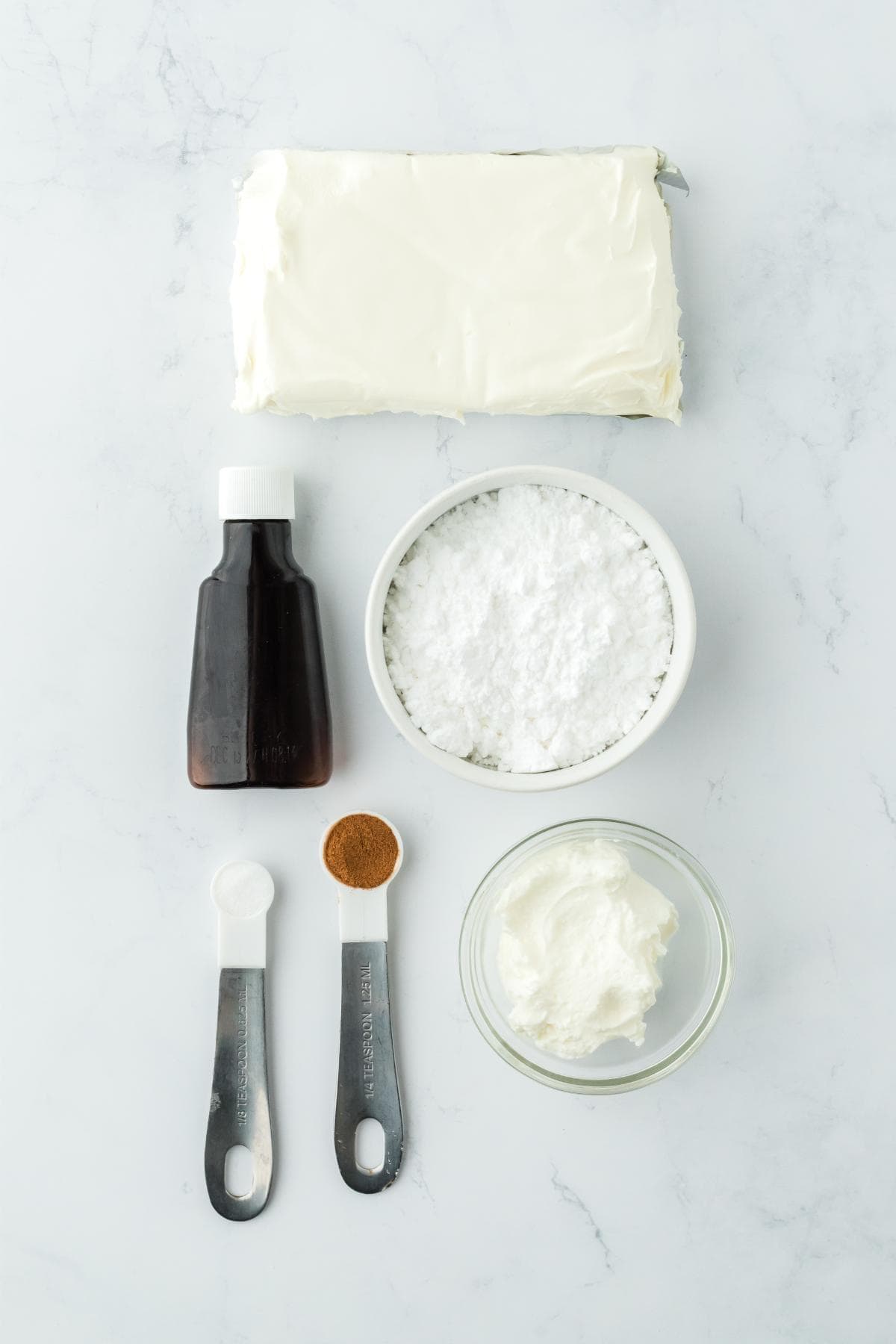 Overhead shot of the ingredients for making cream cheese fruit dip on a marble surface before mixing