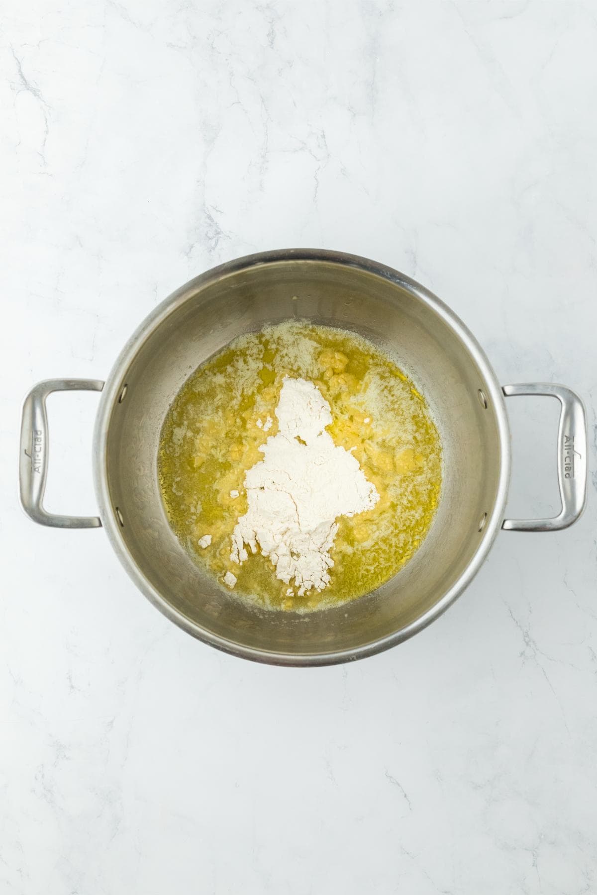 A pot with melted butter and flour, starting the roux for a cheese sauce