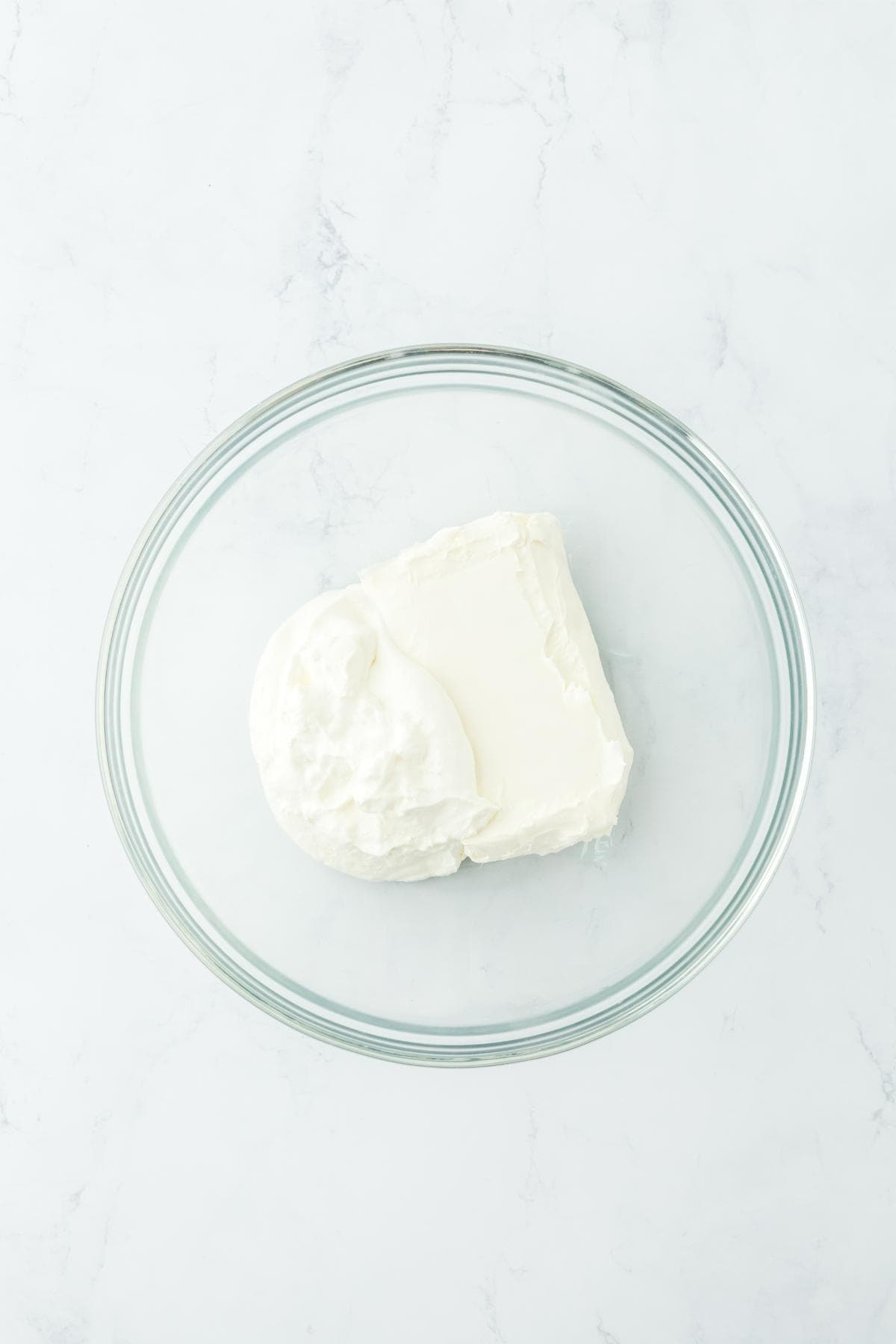 Glass bowl with cream cheese and sour cream before mixing