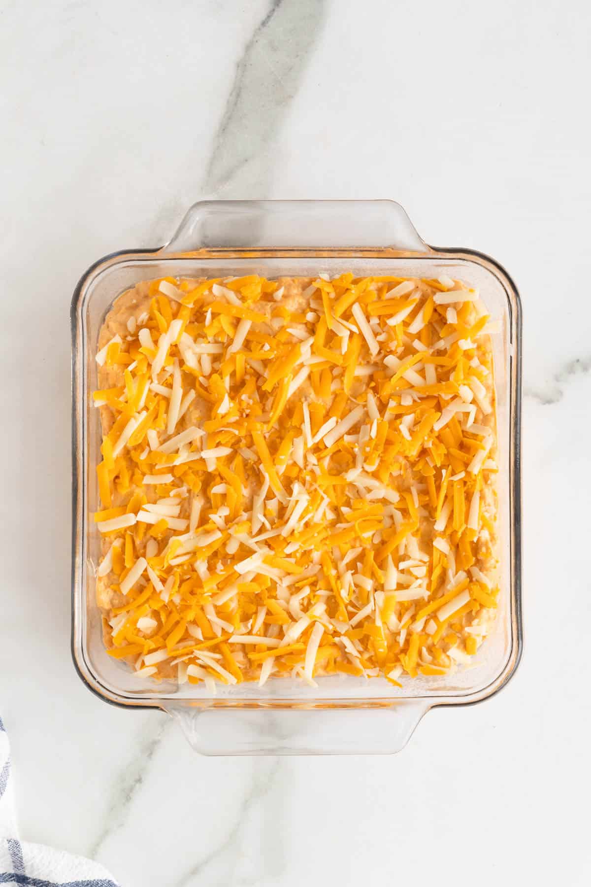 Shredded cheeses added to top of the best buffalo chicken dip recipe