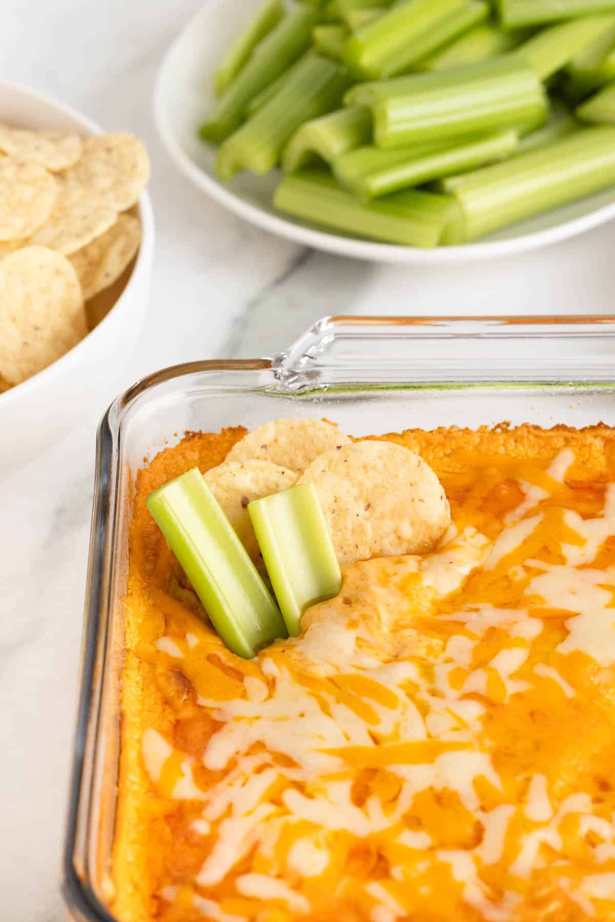 Celery and tortilla chips in an easy buffalo chicken dip ready to eat