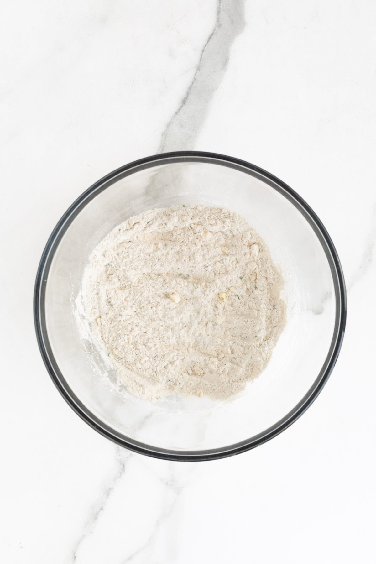 The flour, butter, and herbs mixture after being combined, showing a crumbly texture