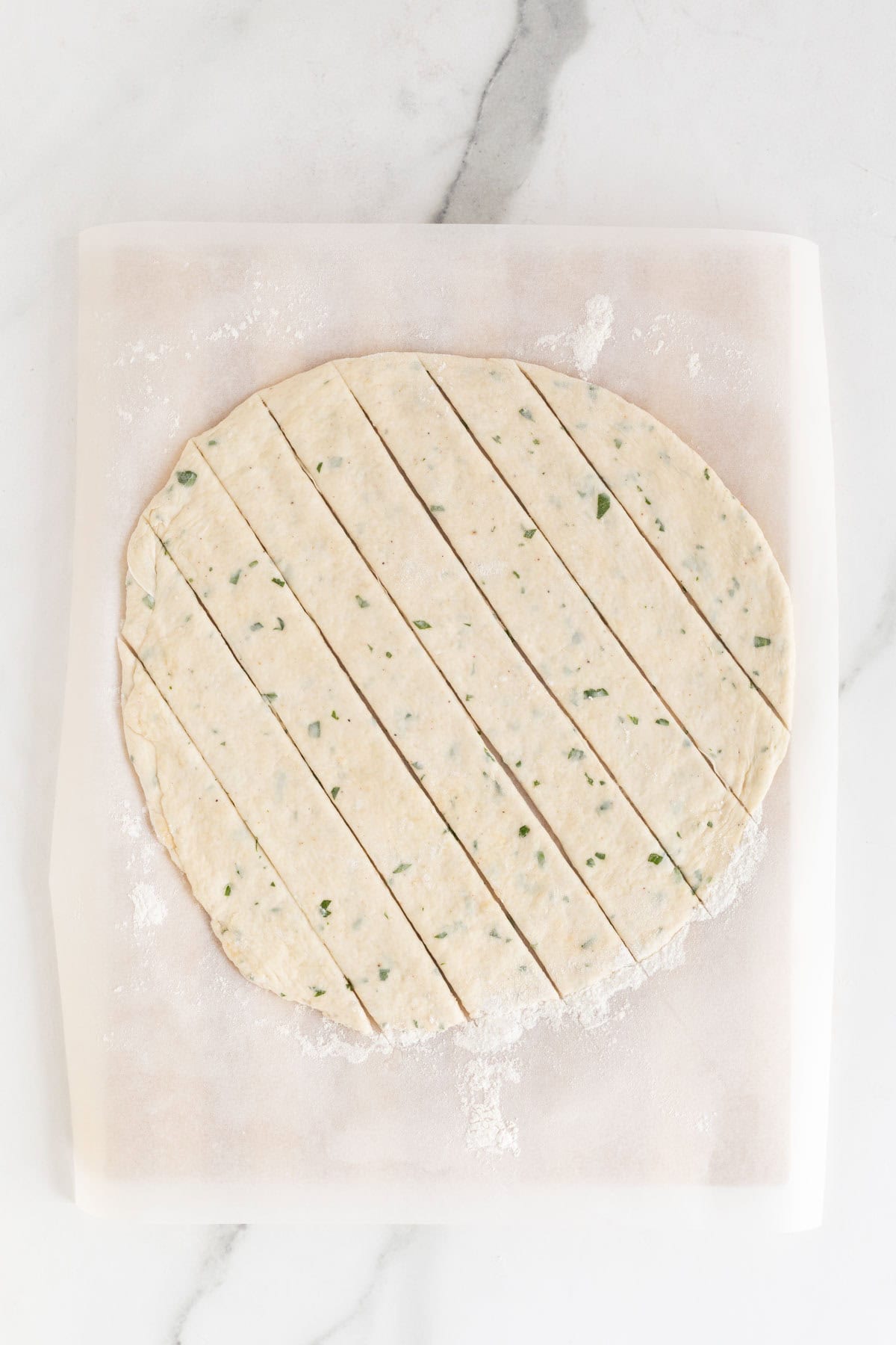 The dough cut into strips on the parchment paper