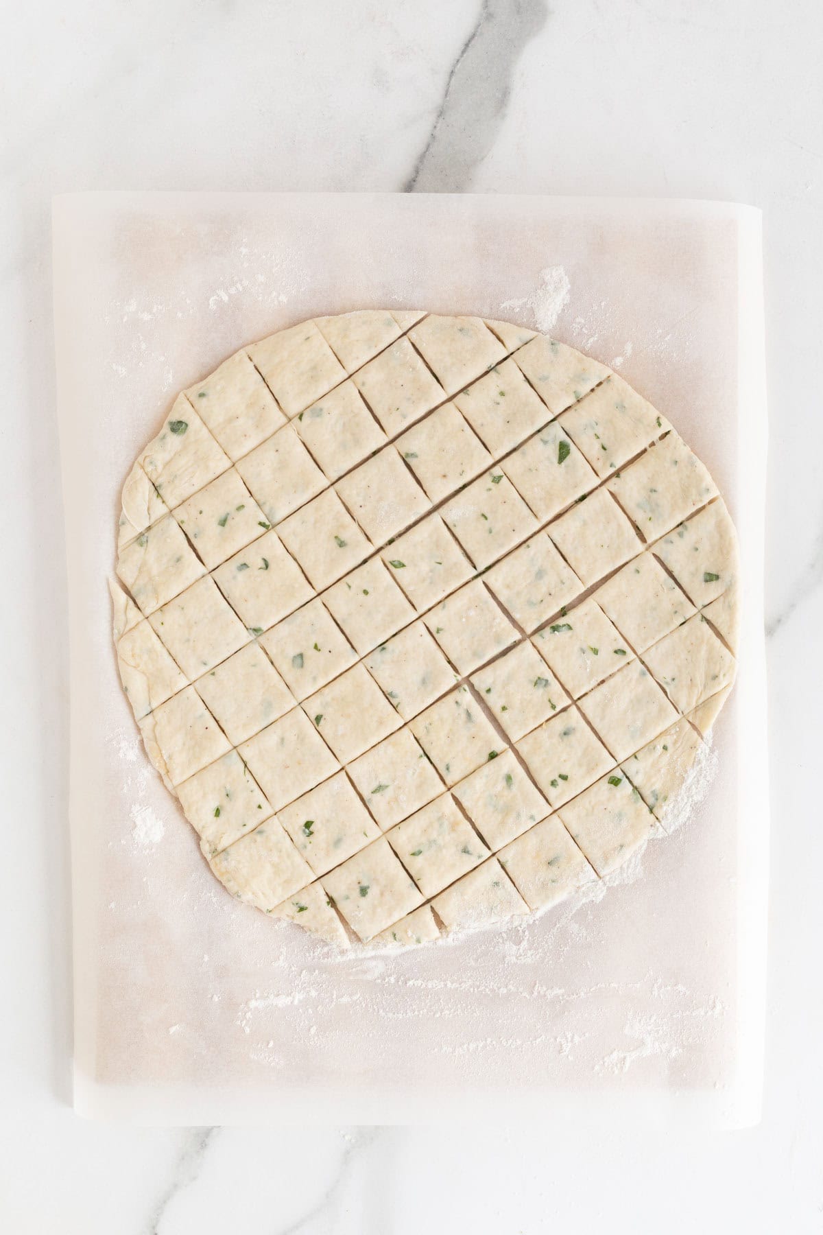 The dough further cut into squares on the parchment paper