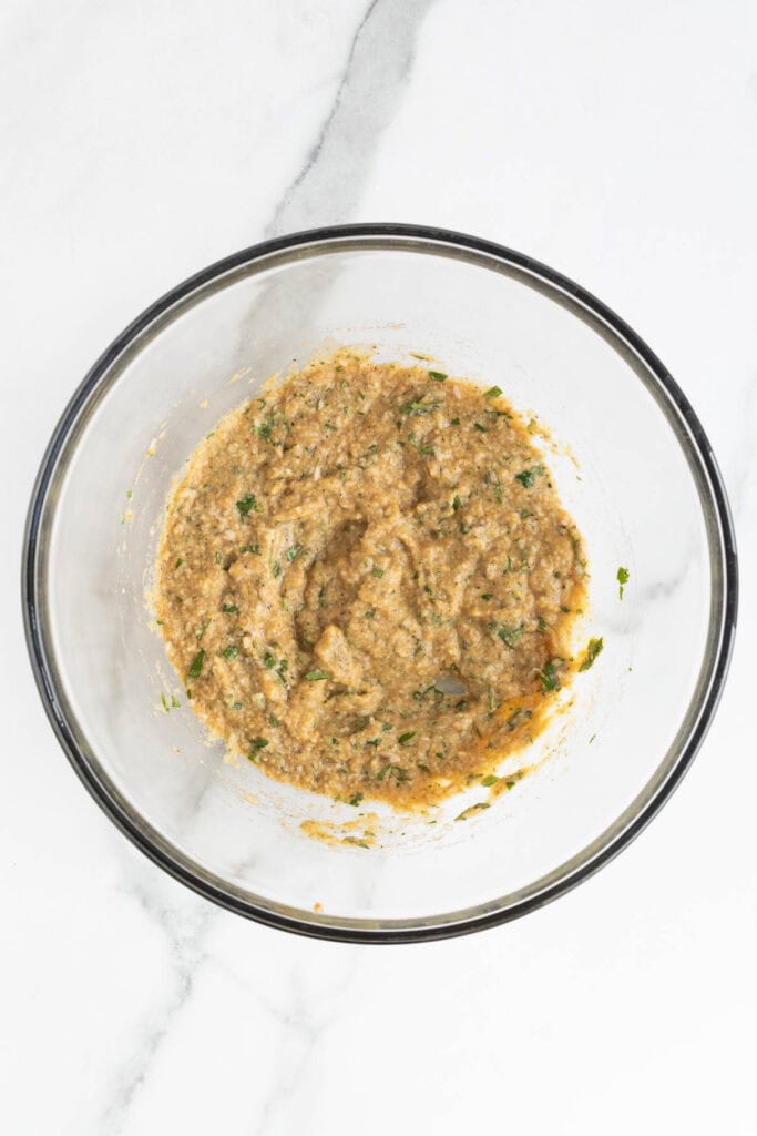 Ingredients in the mixing bowl blended into a thick breadcrumb paste