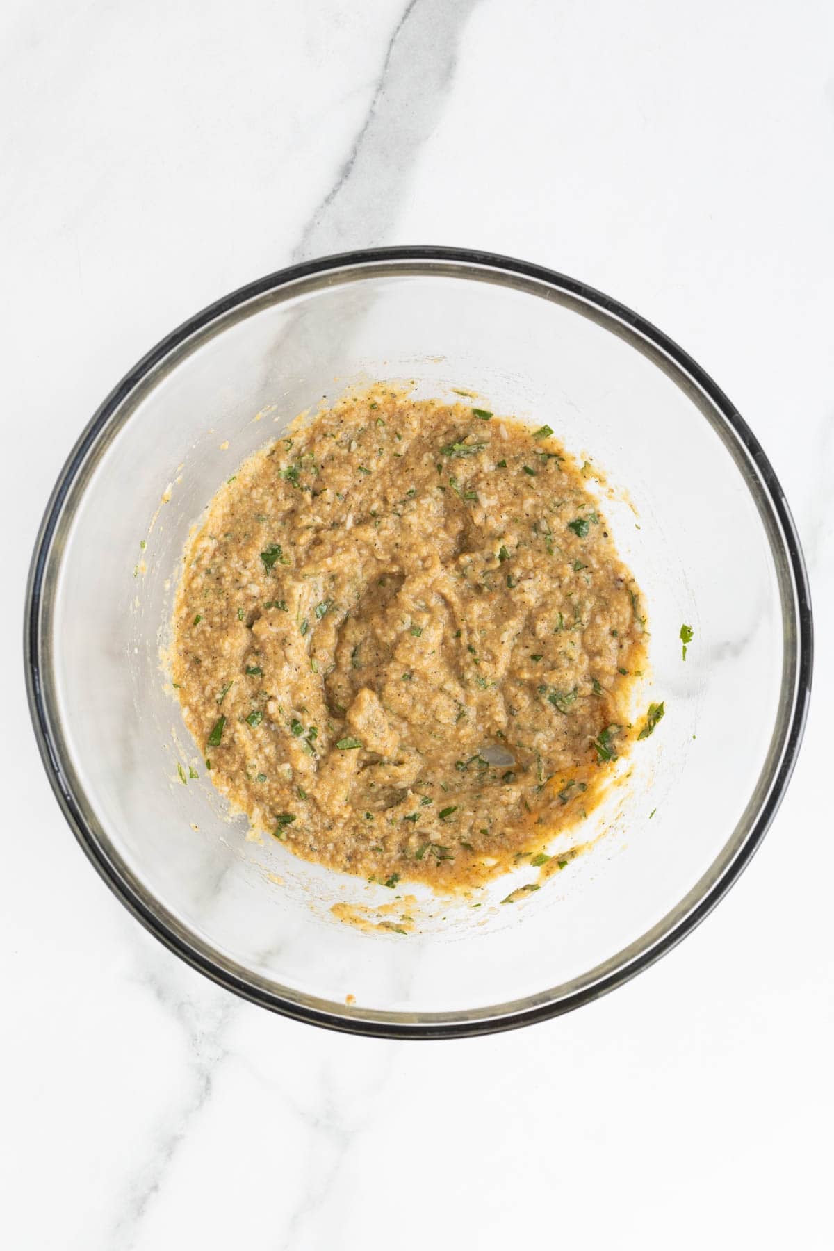 Ingredients in the mixing bowl blended into a thick breadcrumb paste