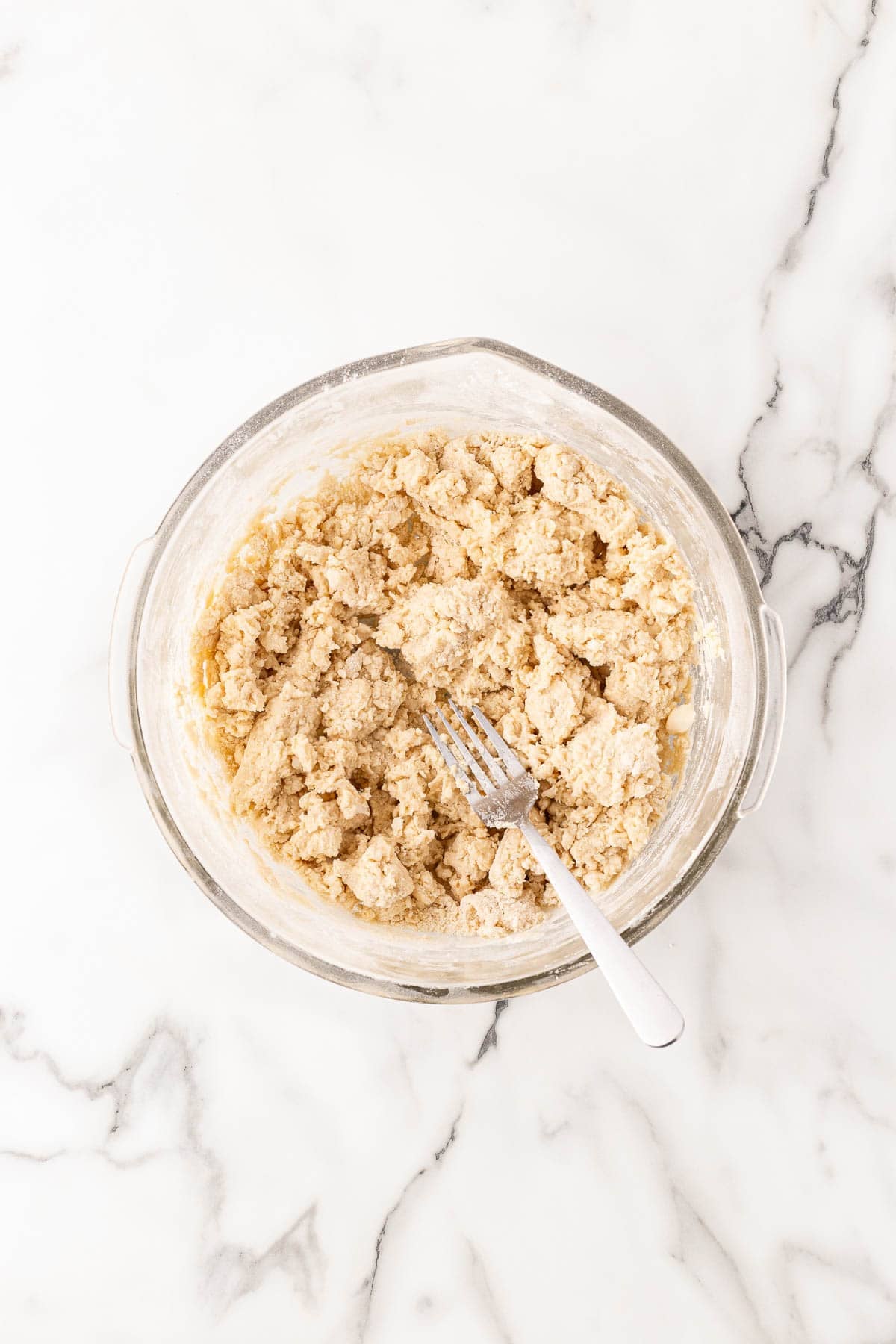 Shaggy buttermilk biscuit dough mixed in bowl with fork