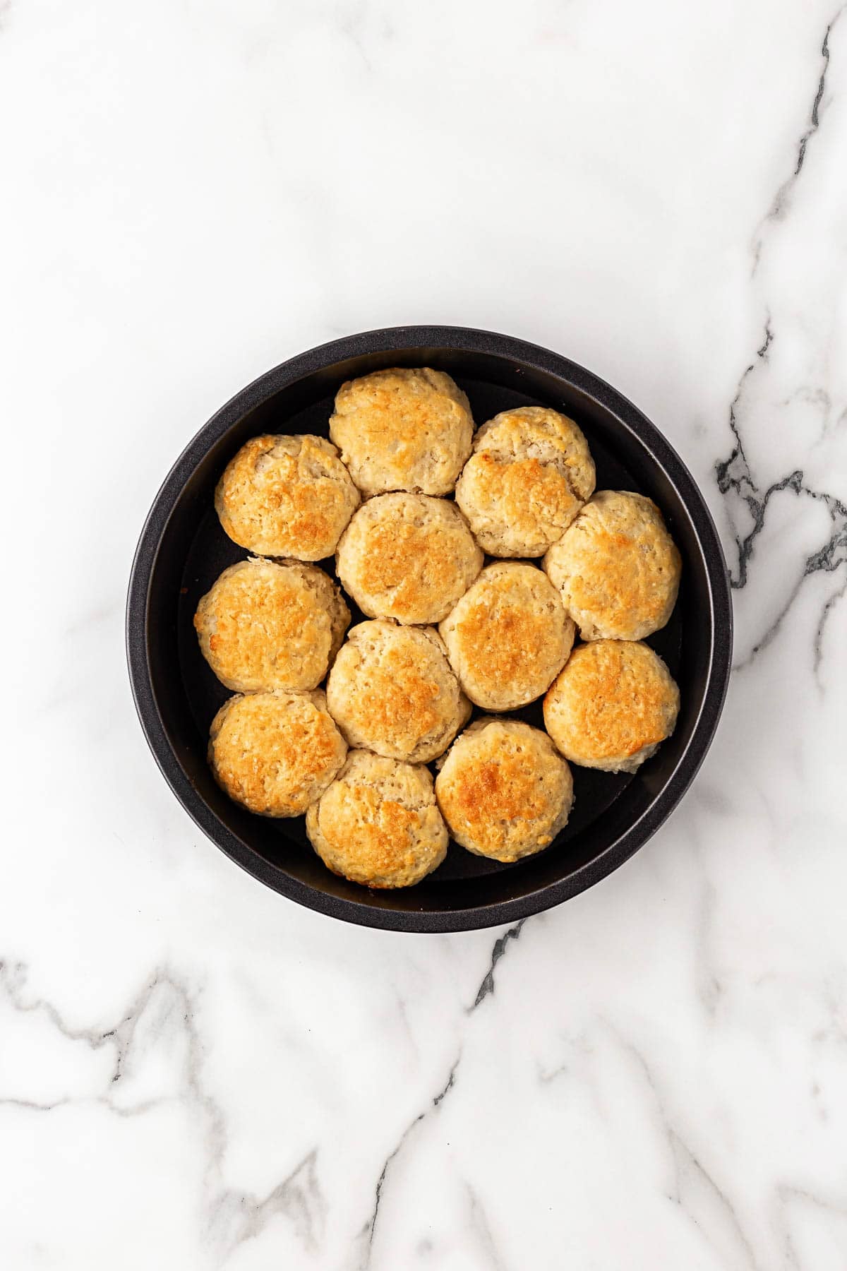 Freshly baked buttermilk biscuits in round baking pan