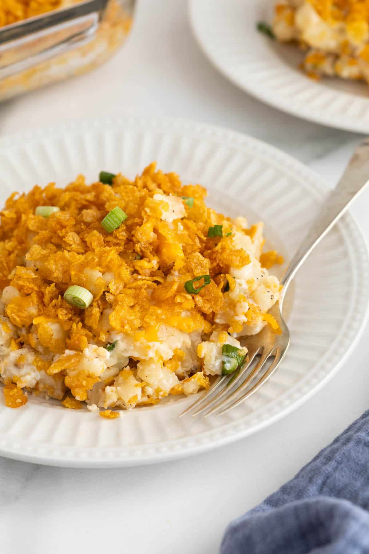 Plated funeral potatoes with a fork