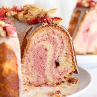 Strawberry crunch cake sliced open on white plate