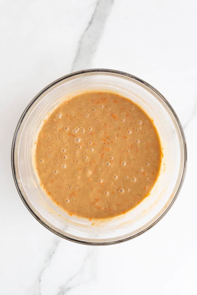Fully mixed carrot cake batter with a smooth, slightly bubbly texture