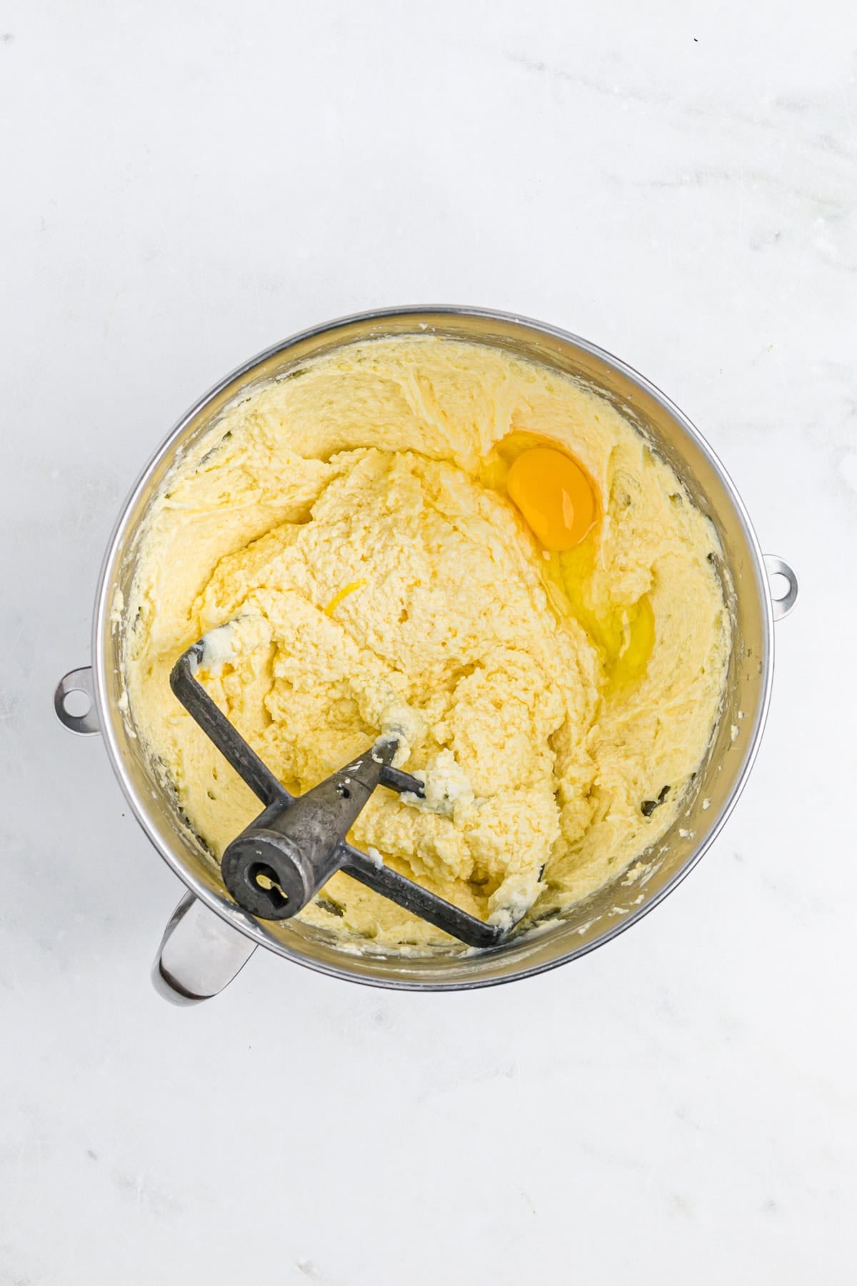Eggs being added to mixing bowl with creamed butter and sugar