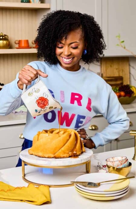 Jocelyn pouring dressing over fresh cake