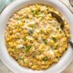 A close up of homemade cream corn recipe ready to serve with a spoon to enjoy