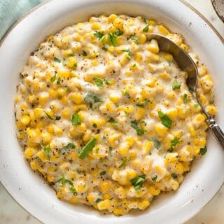 A close up of homemade cream corn recipe ready to serve with a spoon to enjoy