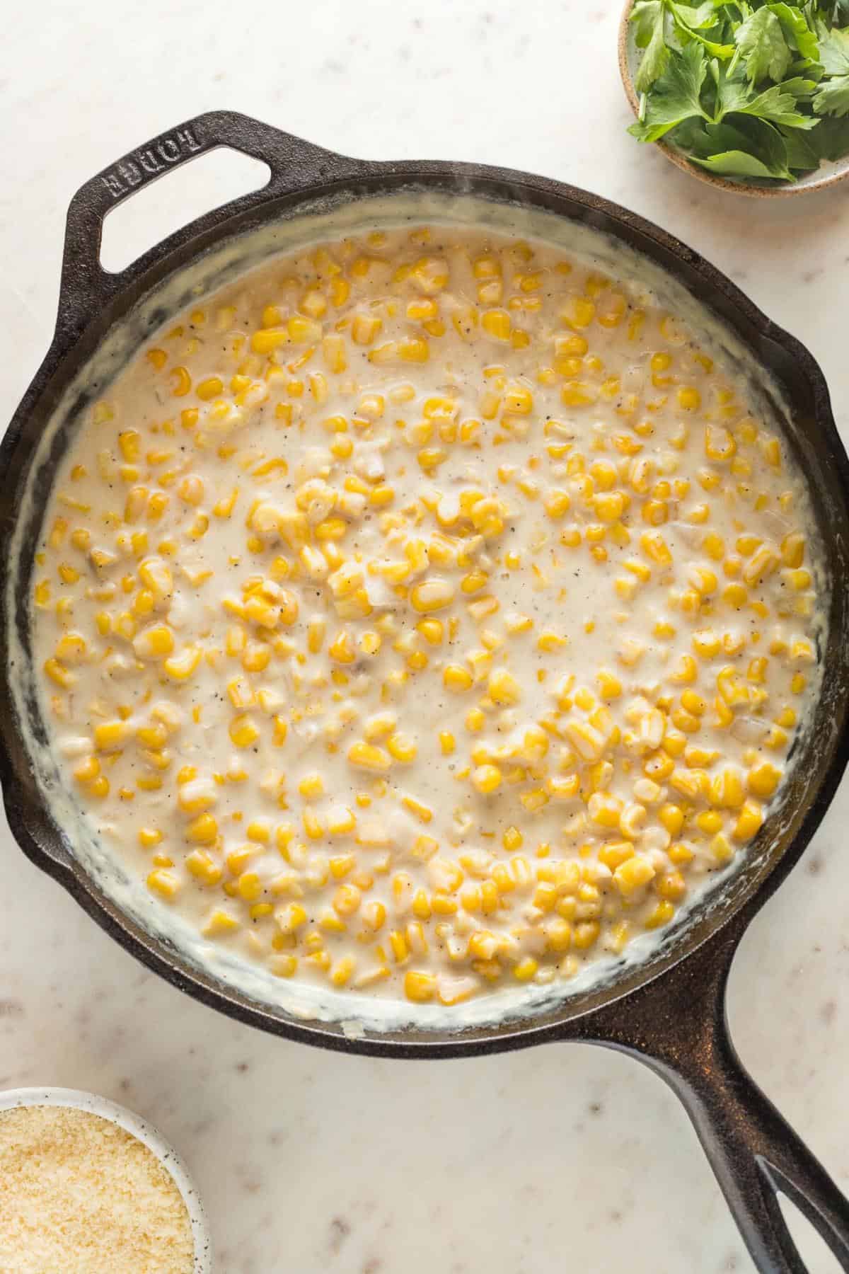 Creamy corn in a cast iron skillet with a flour and milk slurry mixed in