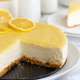 A sliced open lemon cheesecake on a white plate