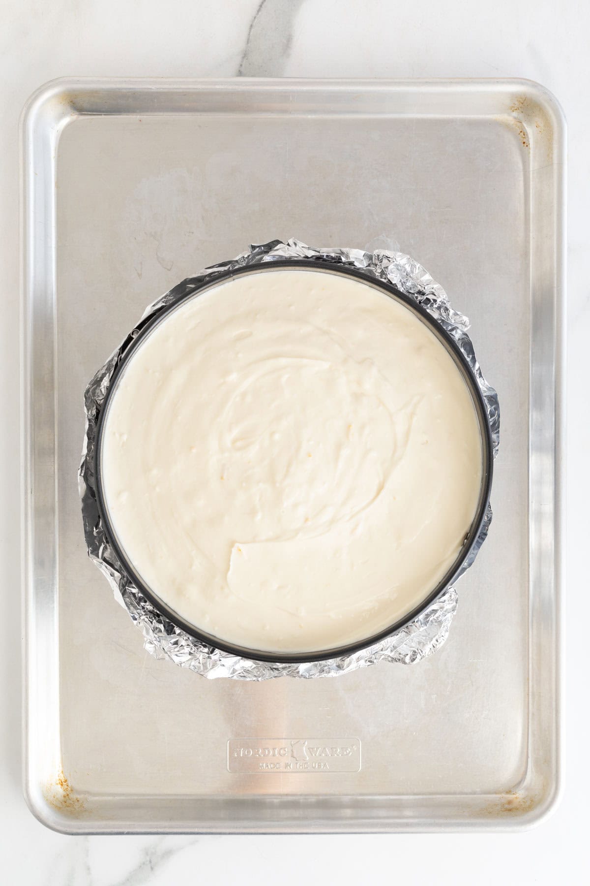 Unbaked lemon cheesecake filling poured into the springform pan, ready for the oven