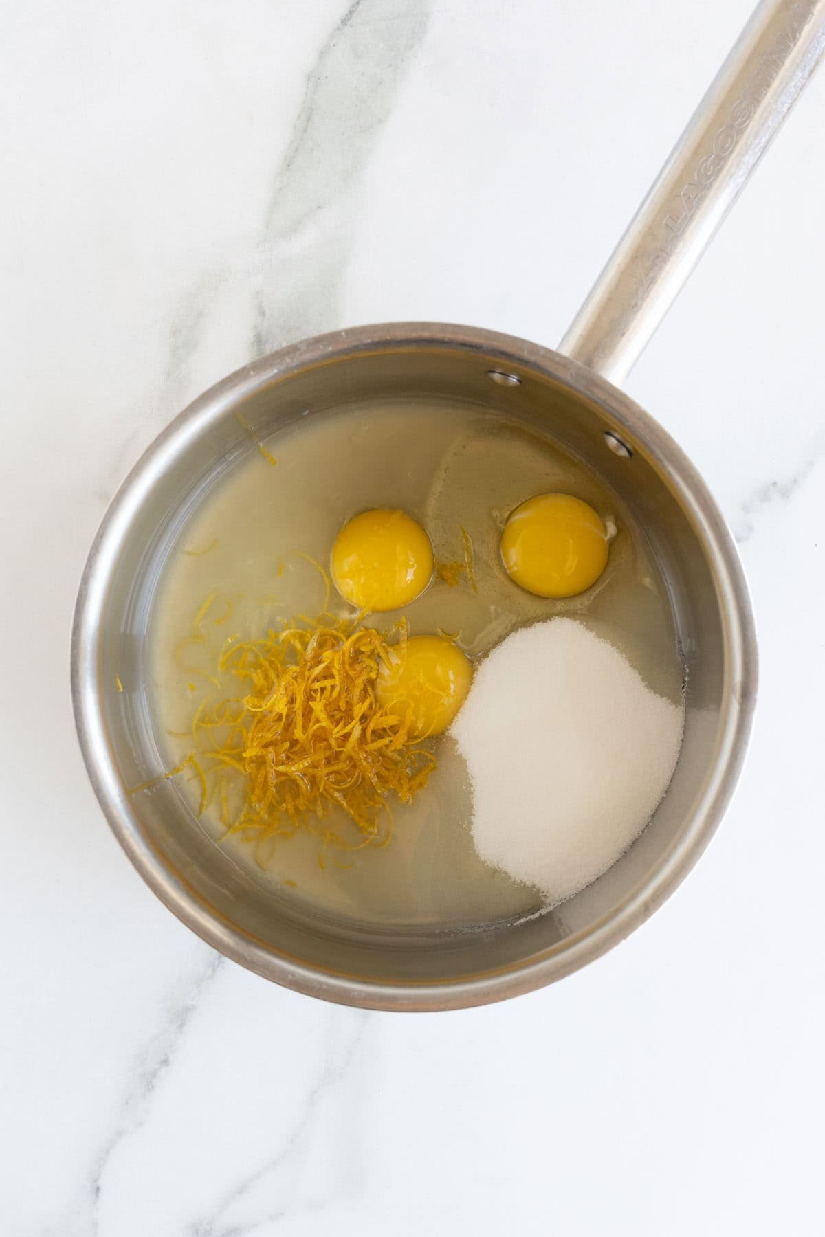 Saucepan with eggs, sugar, lemon juice, and lemon zest before making curd