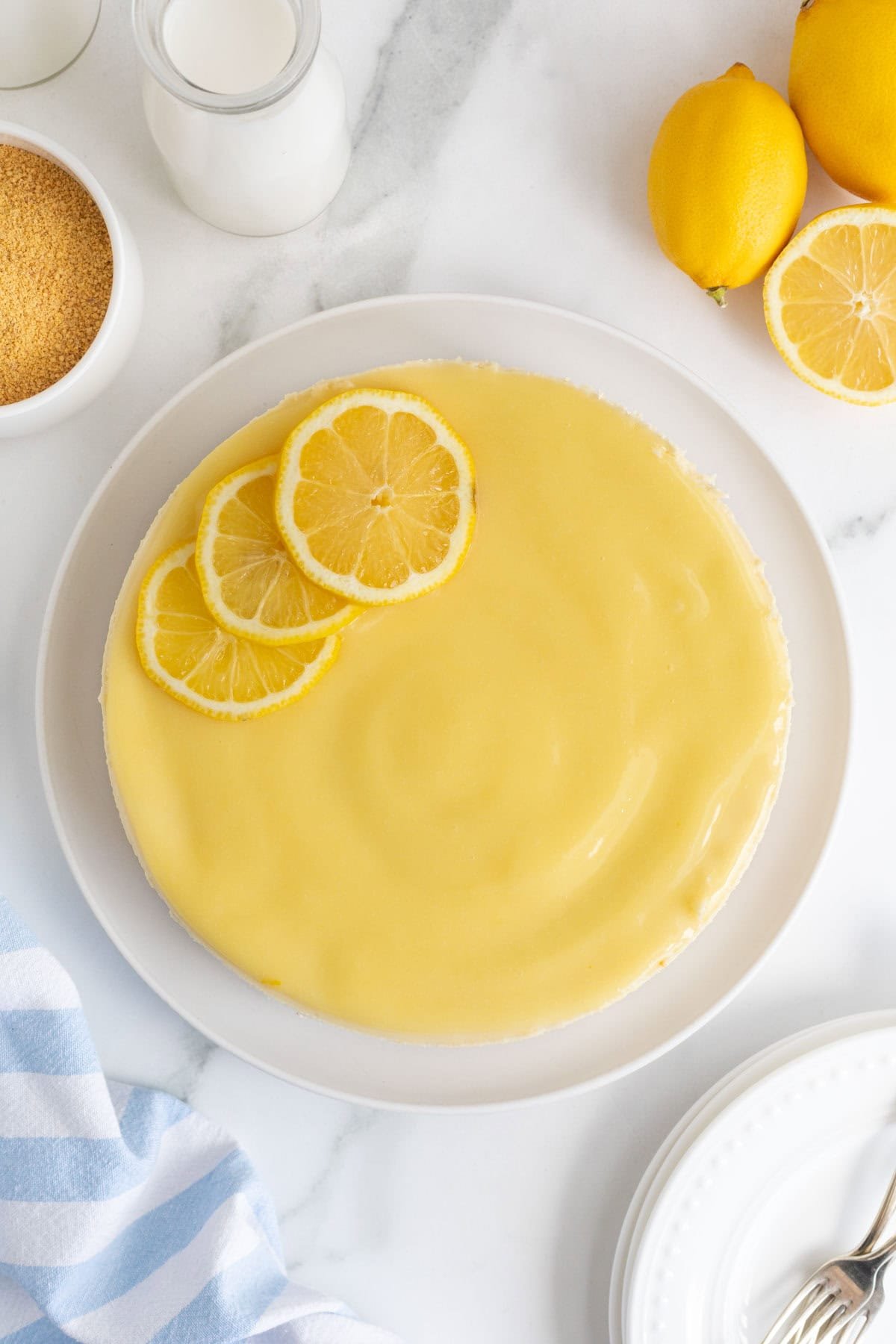 Finished lemon cheesecake topped with lemon curd and garnished with fresh lemon slices