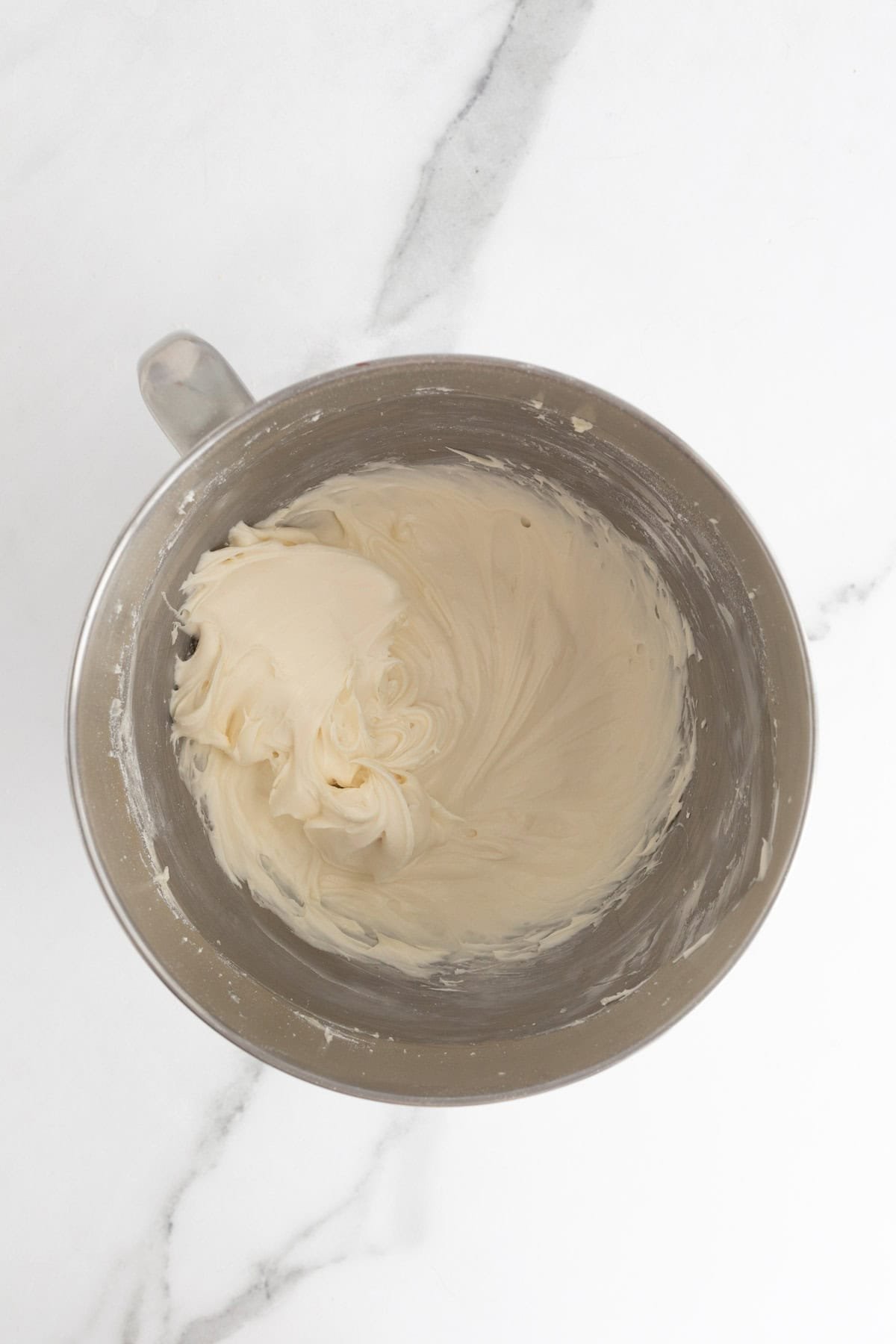 Smooth and creamy cream cheese frosting fully whipped in the bowl