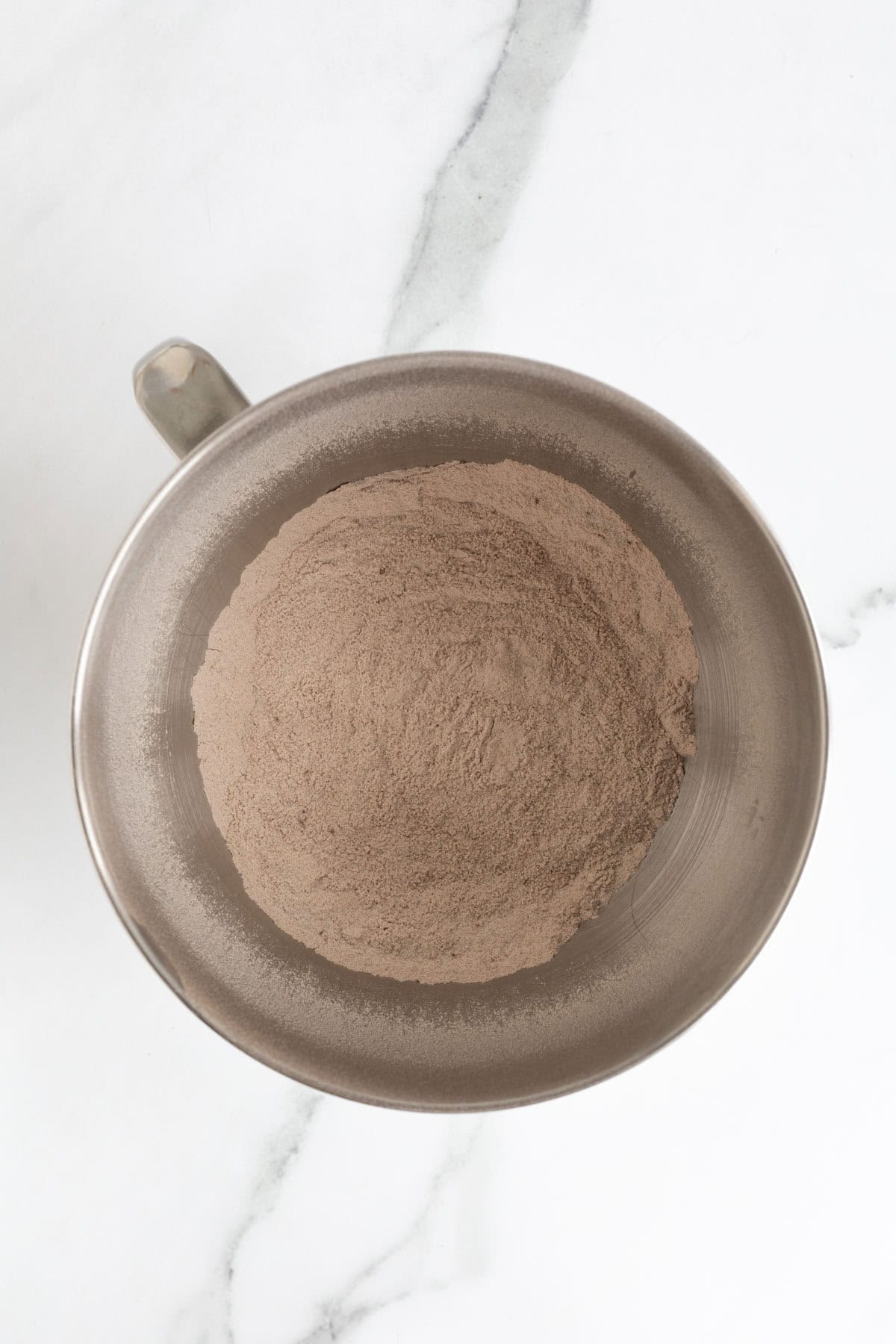 Dry ingredients whisked together into a smooth cocoa-colored mixture in a bowl
