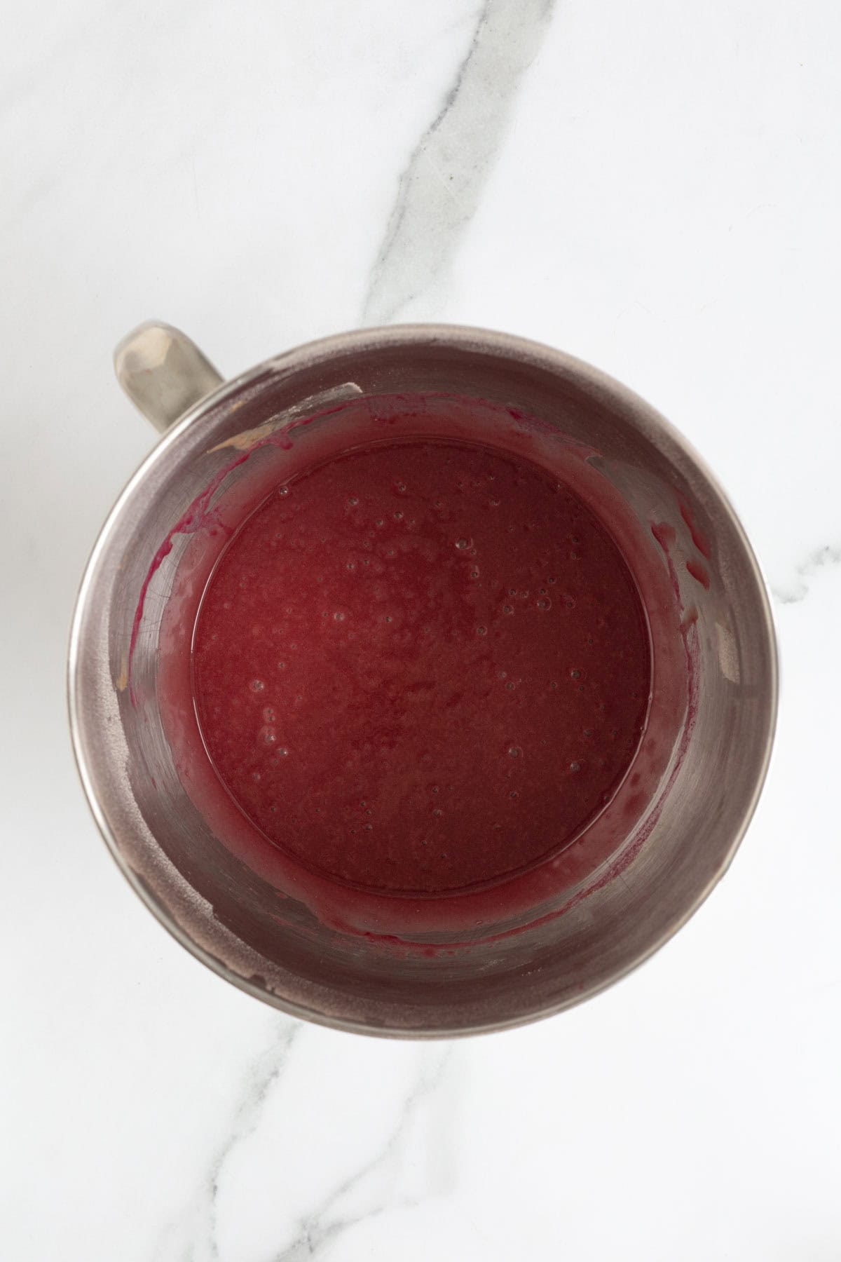 Fully mixed red velvet cupcake batter, smooth and vibrant in color
