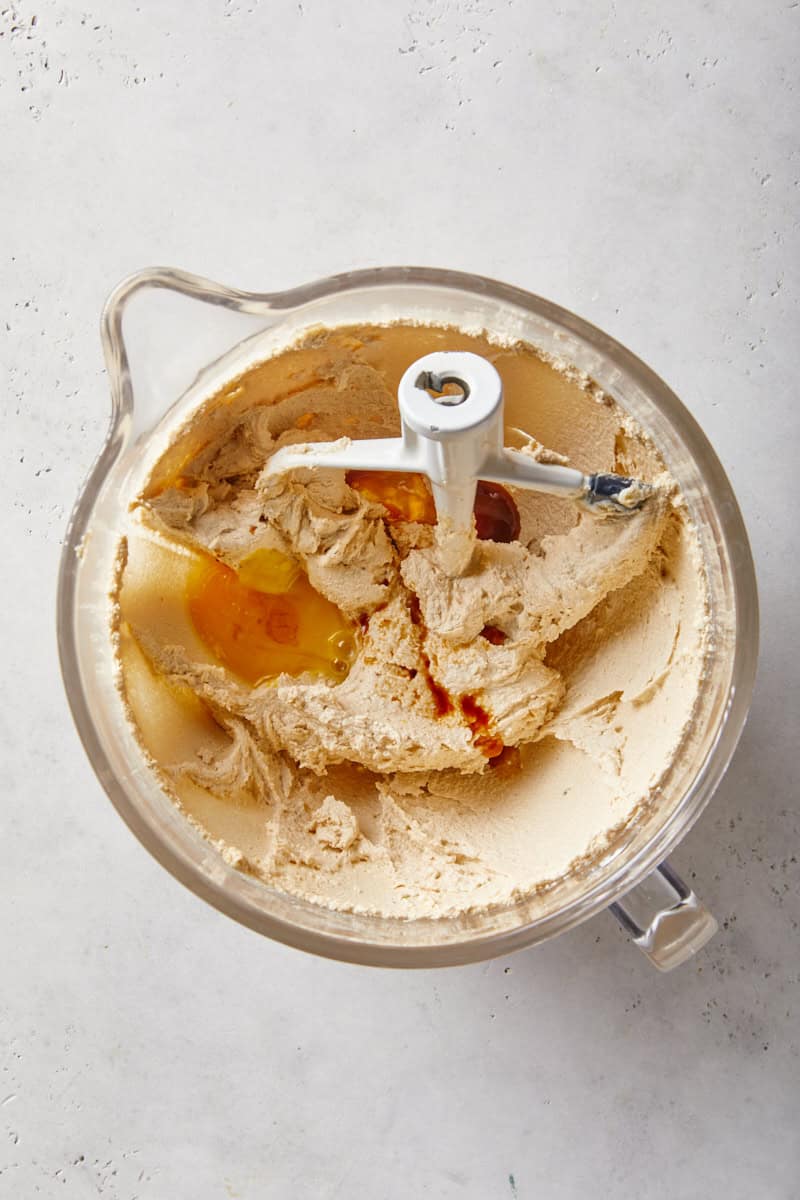Eggs and vanilla added to creamed butter and sugar in a stand mixer bowl