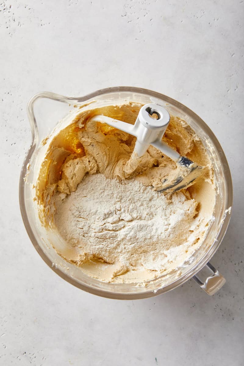 Flour mixture added to the cookie dough in a stand mixer bowl