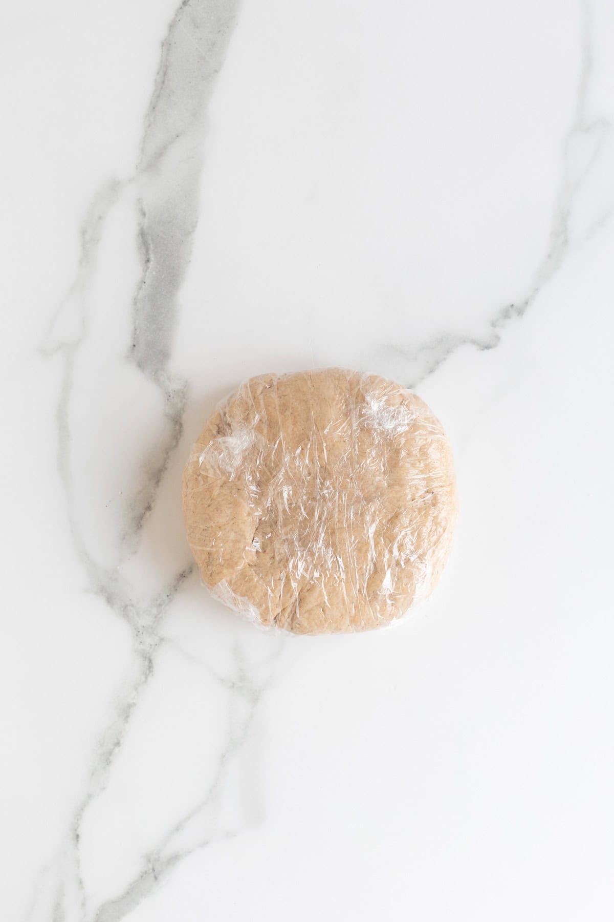 Dough wrapped tightly in plastic wrap, ready to chill