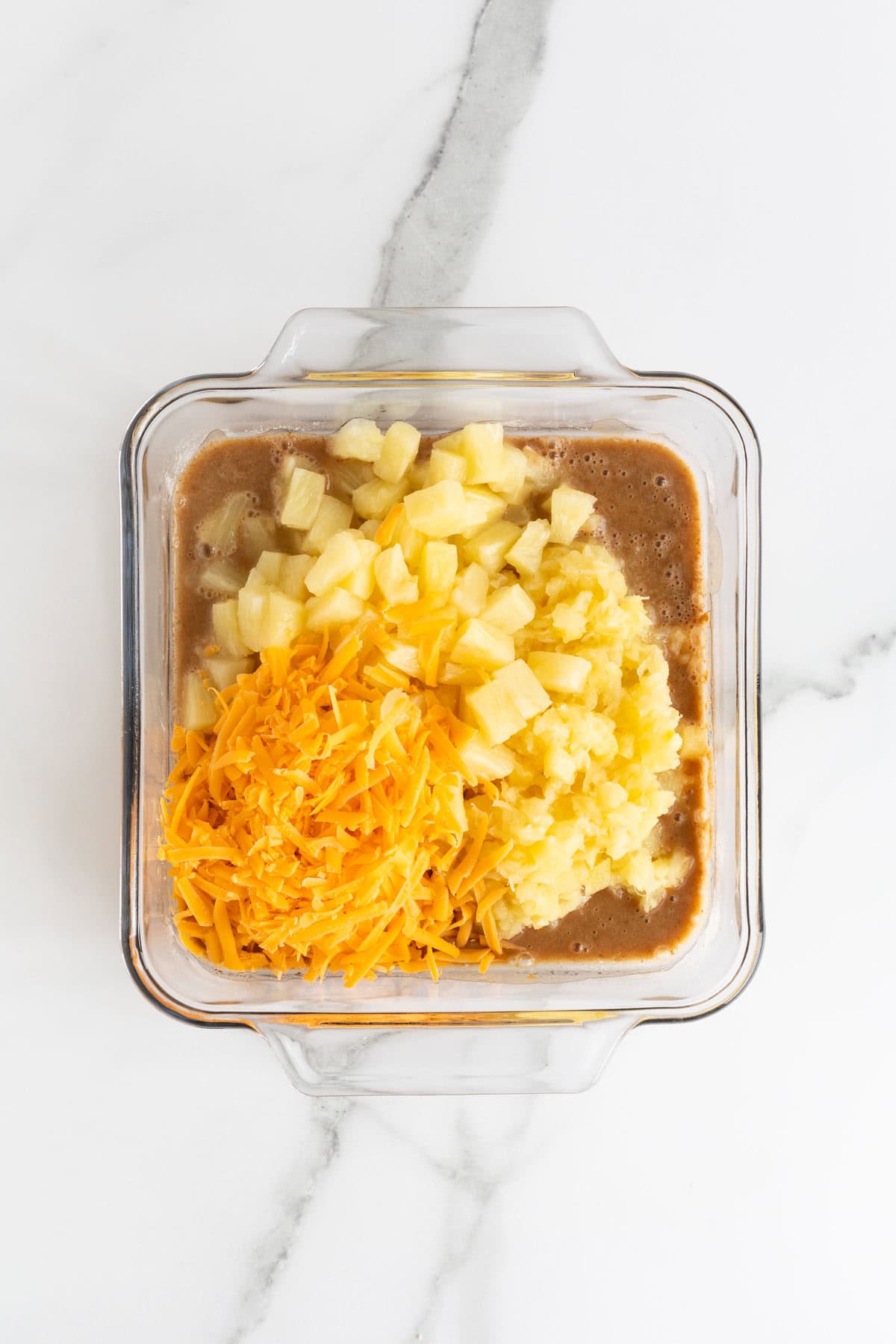 Chopped pineapple and shredded cheddar cheese added on top of the batter