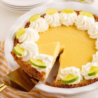 a slice of key lime pie being lifted out of a pie plate