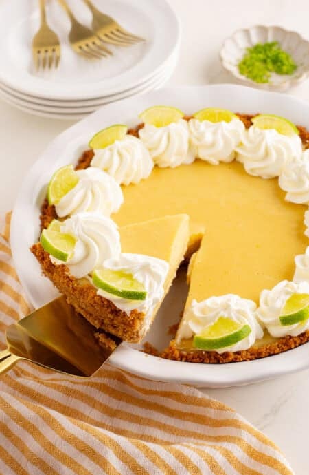 a slice of key lime pie being lifted out of a pie plate