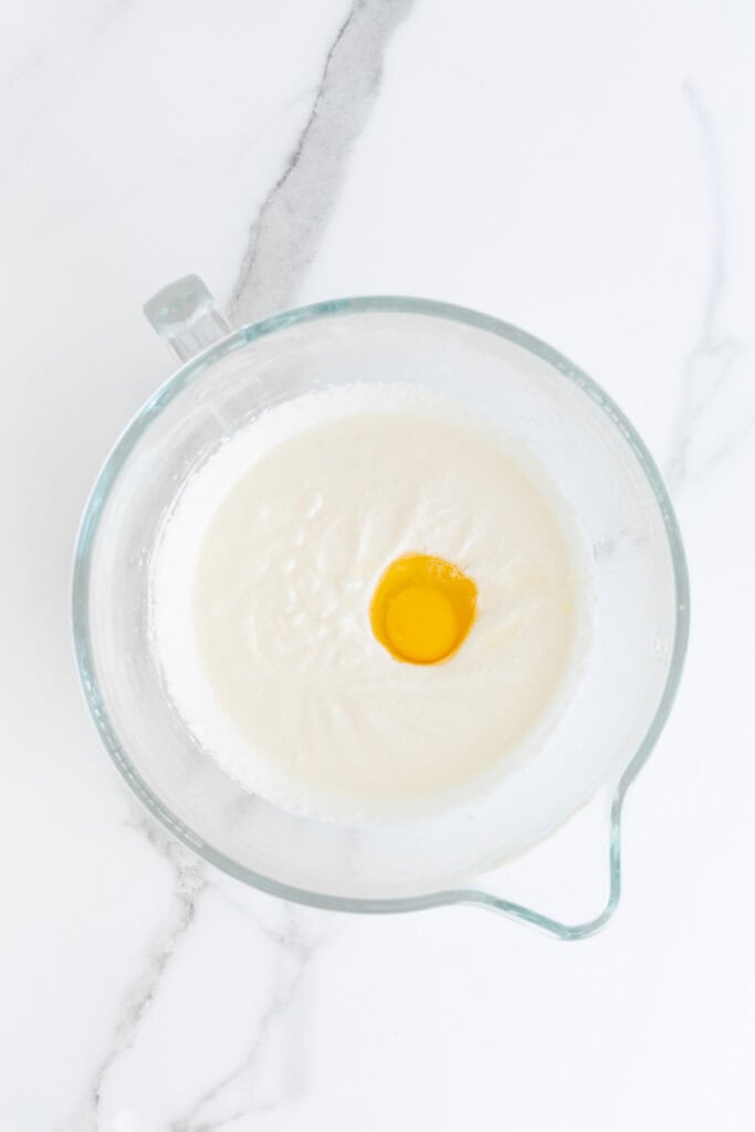 Egg added to cake batter in mixing bowl
