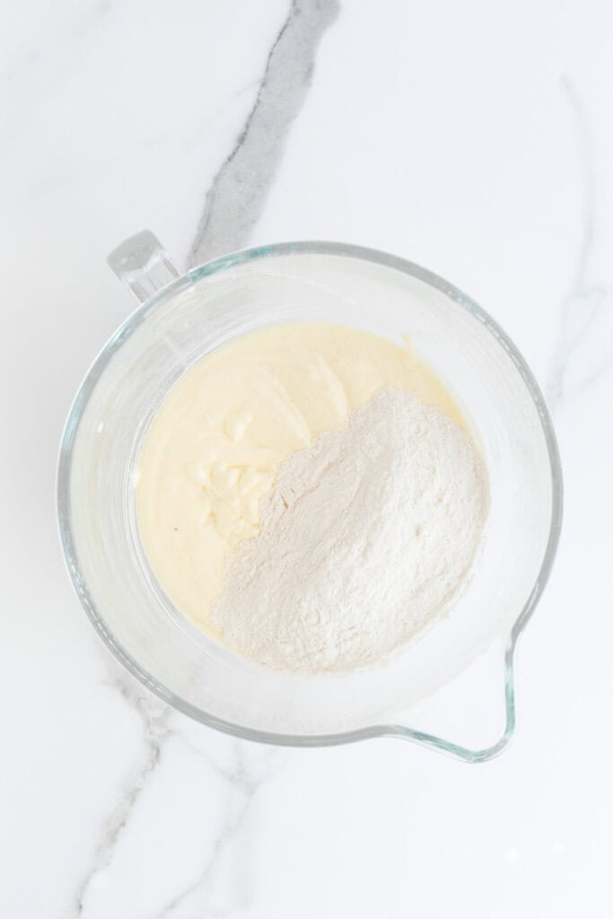 Flour and leavening added to cake batter in stand mixer bowl