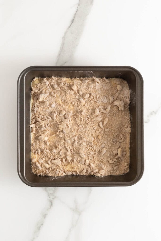 Crumble added to half of cake batter in baking pan