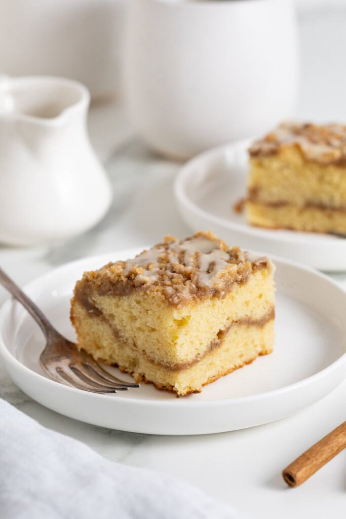 Slices of coffee cake on white plates with a fork ready to serve