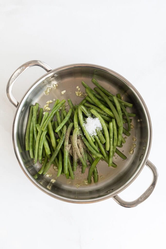 Green beans added to pan with garlic and other ingredients