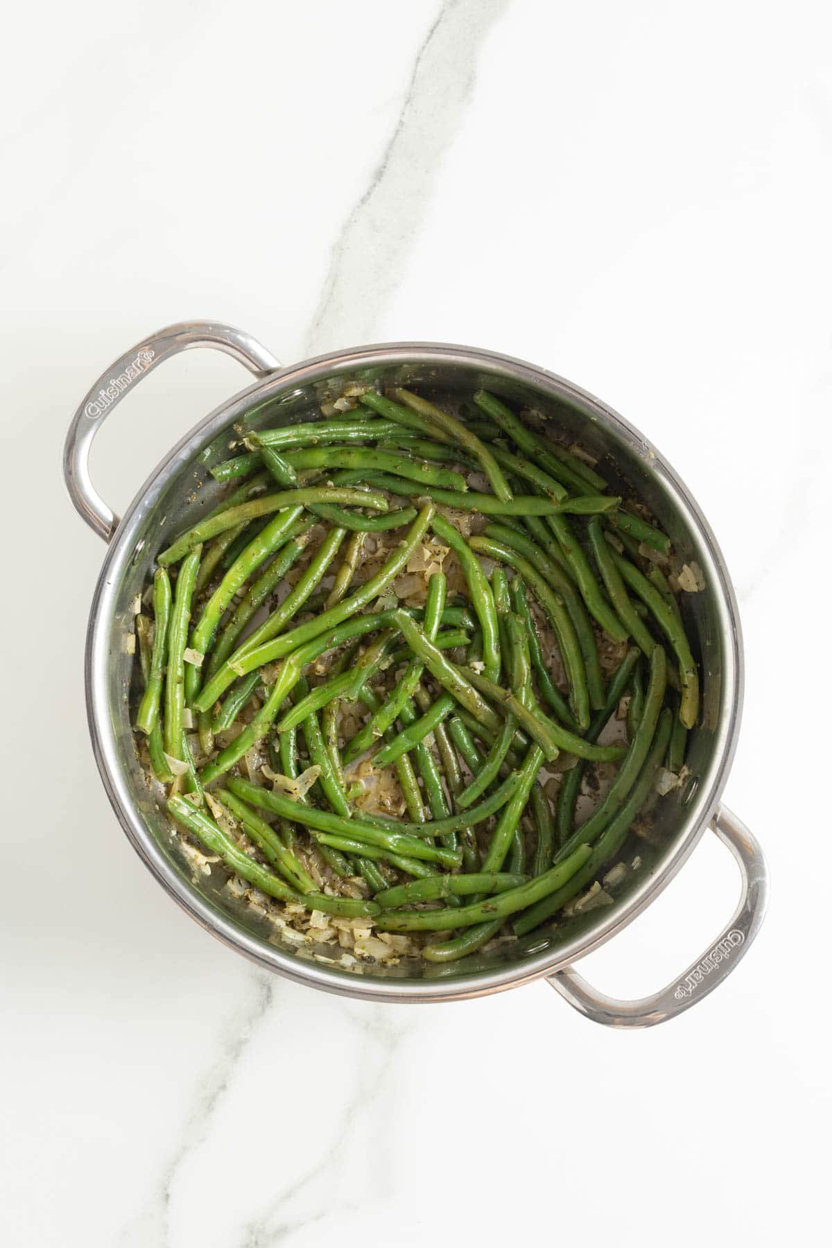 Green beans evenly cooked and well coated in seasoning in the skillet