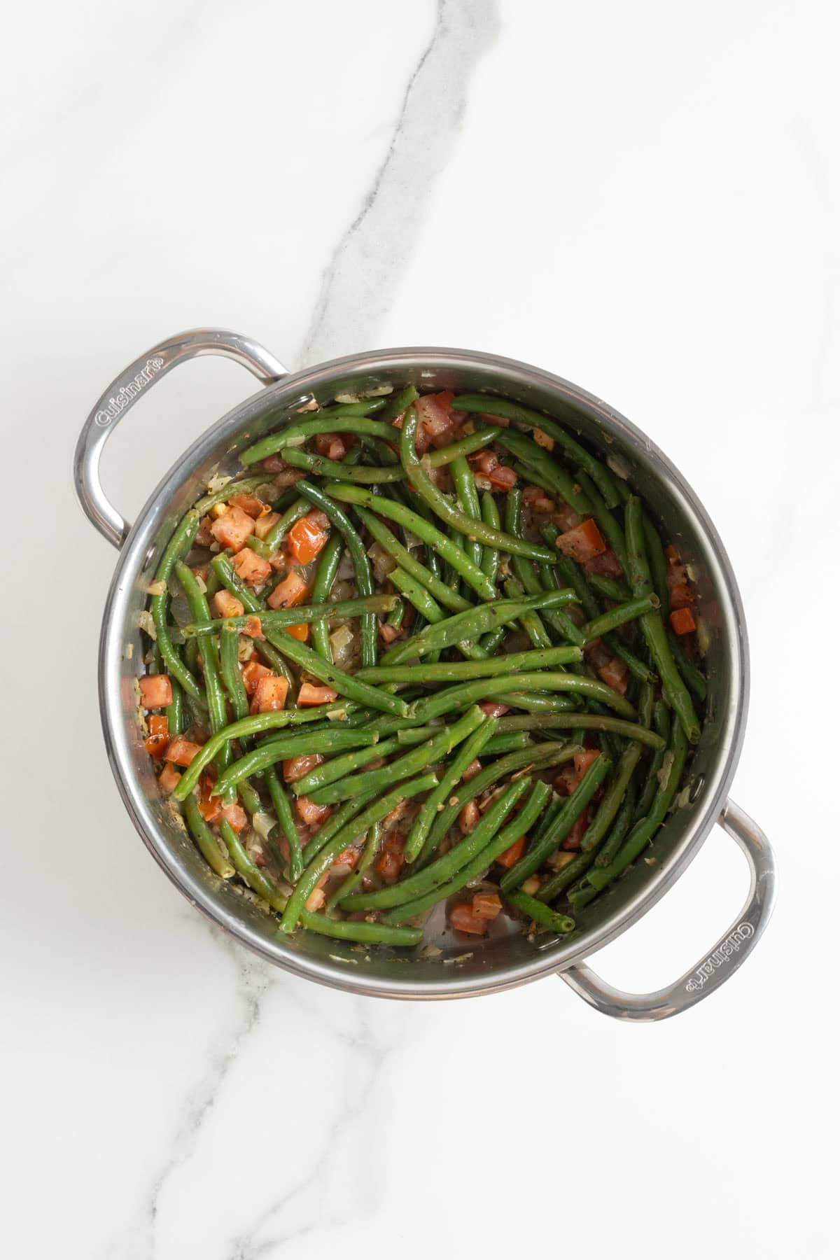 Diced tomatoes added to the skillet with green beans, onions, and seasoning