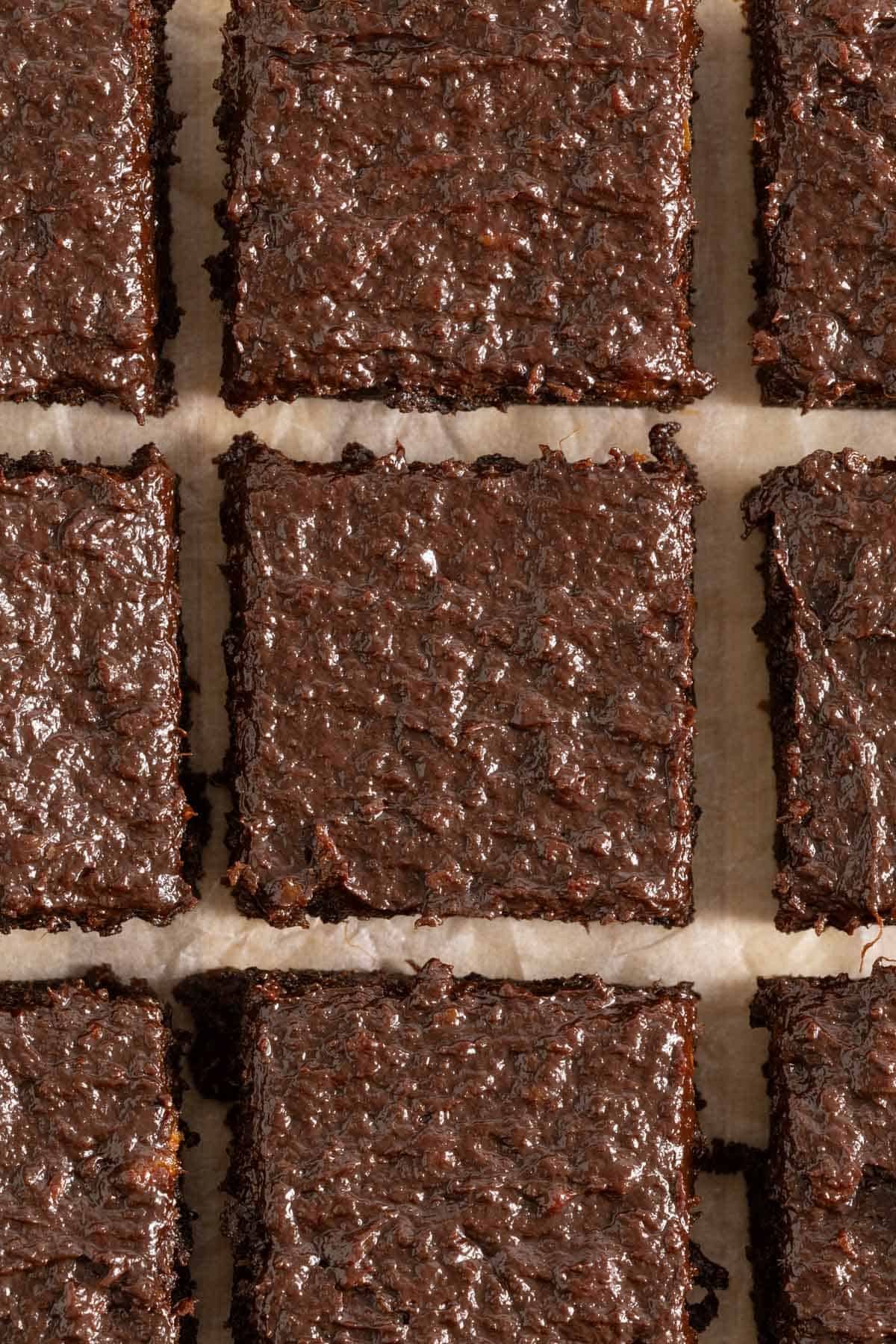 Overhead shot of moist and shiny sweet potato brownies cut into squares, showing their fudgy texture