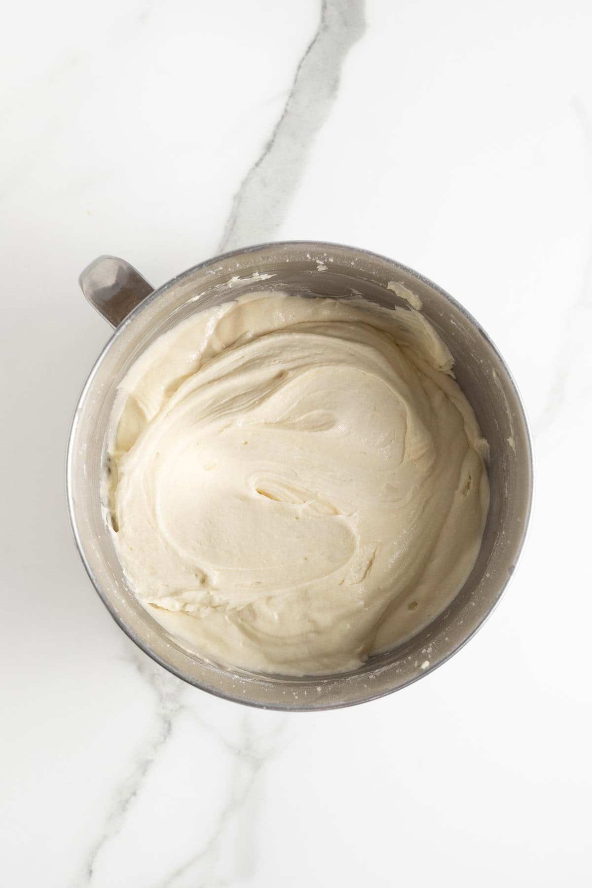 Smooth, fully mixed cake batter in a metal bowl