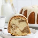 A single slice of tiramisu pound cake on a small plate in front of the whole cake