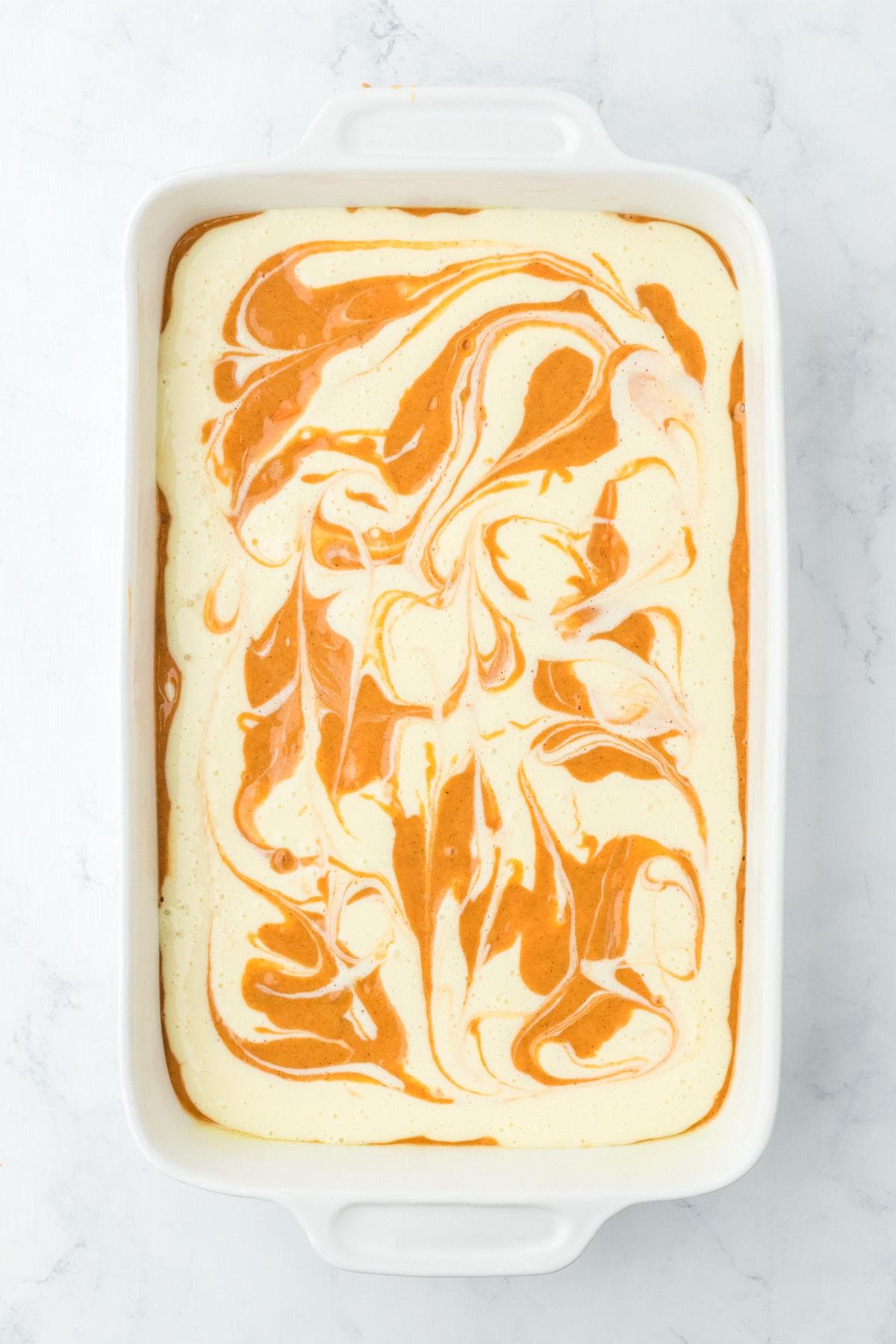 Swirled carrot and cream cheese batter in baking dish