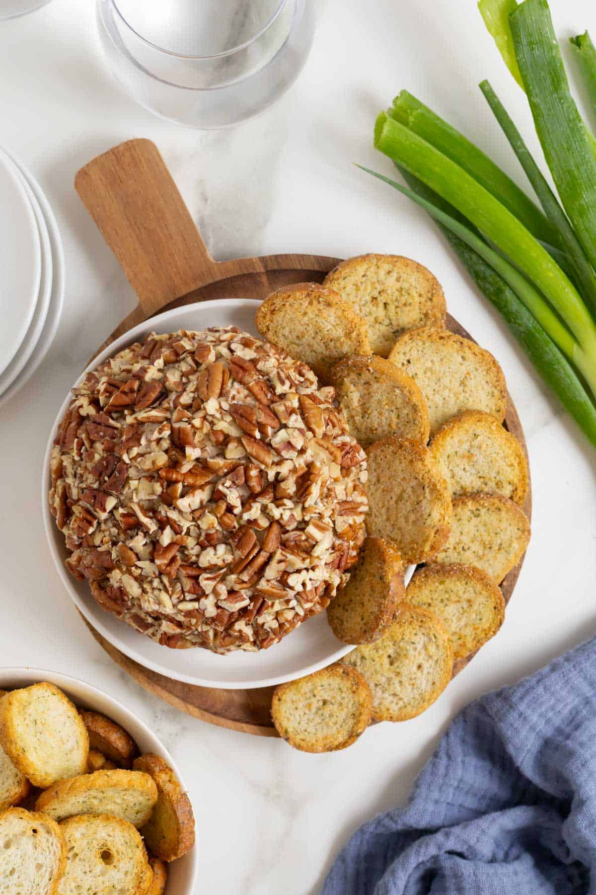 Creamy pecan-covered cheese balls with crunchy toasted coconut, served with crackers and fresh green onions.