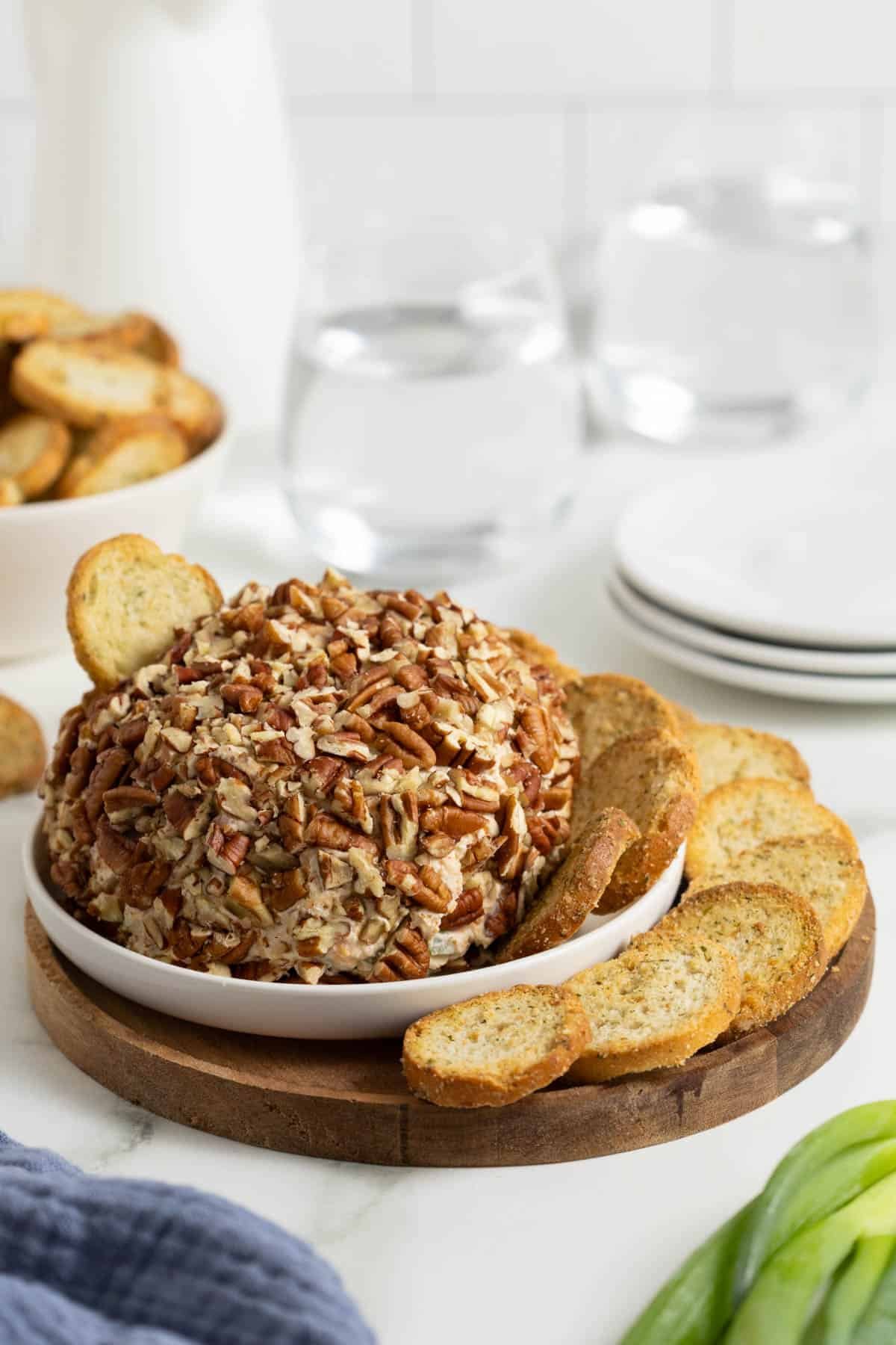 Creamy pecan-covered cheese balls served with crackers and fresh green onions.