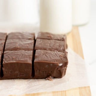 Side angle of chocolate fudge squares with milk bottles blurred in background