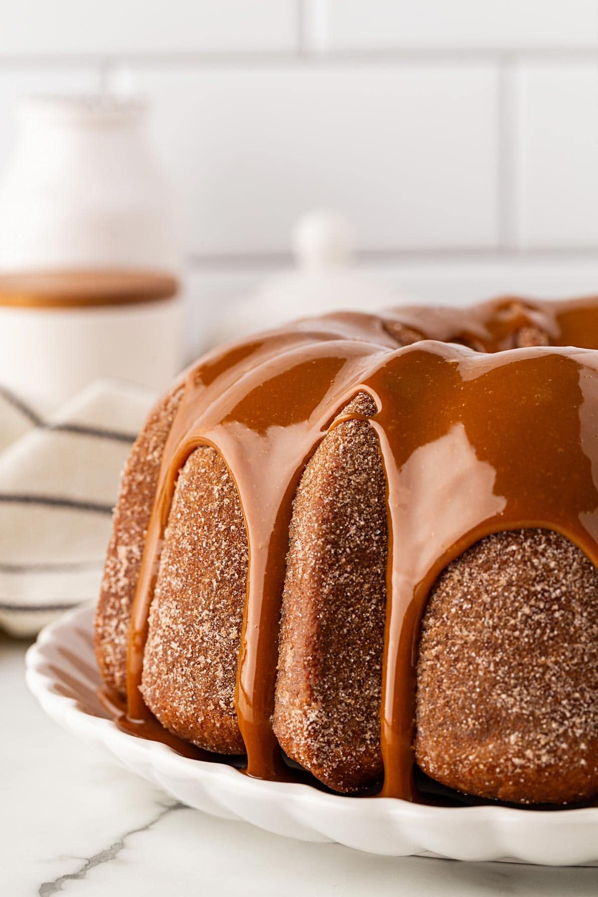 Closeup of churro pound cake covered in dulce de leche glaze dripping down the sides