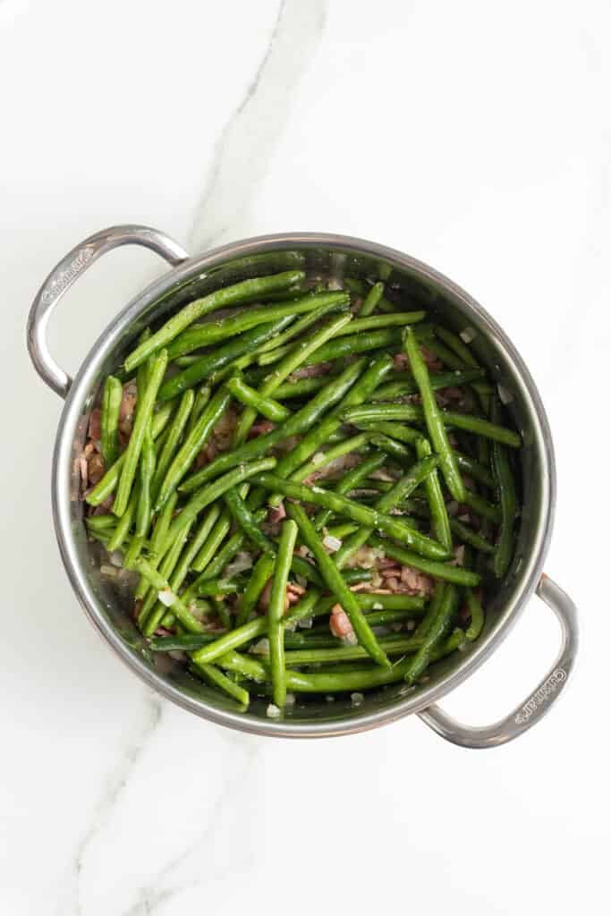 Green beans cooking in water with spices